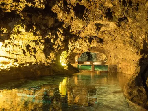 Beleuchtete Höhlen von São Vicente mit einem ruhigen Wasserbecken und Aquarien.