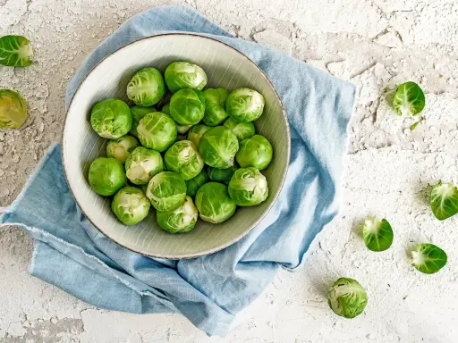 Un bol de choux de Bruxelles frais, prêts à être cuisinés. Ces légumes verts sont parfaits pour une alimentation saine, loin de toute maladie choux de bruxelles.