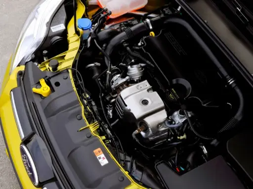 Silnik EcoBoost w żółtym Fordzie, z widocznym logo Ford i elementami układu dolotowego.