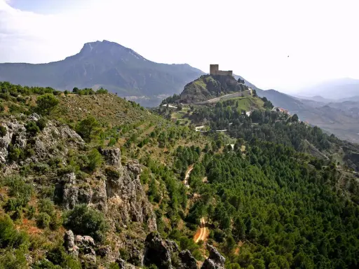 Castillo en la cima de una colina, rodeado de bosques y montañas. Un lugar perfecto que ver en Segura de la Sierra.