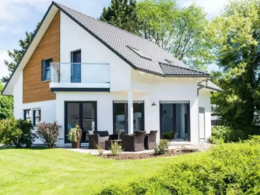 Maison moderne avec balcon, terrasse et jardin. Un projet de construction de maison qui respecte le budget.