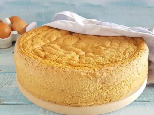 Gâteau moelleux, prêt à être décoré. La base parfaite pour toute recette génoise. Des œufs frais en arrière-plan.