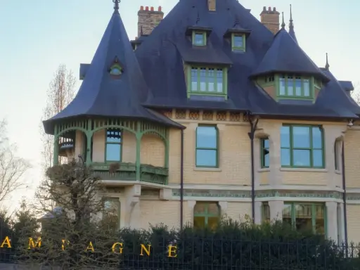 La villa Demoiselle Pommery, une demeure Belle Époque aux toits d'ardoise et aux ornements verts, se dresse fièrement.
