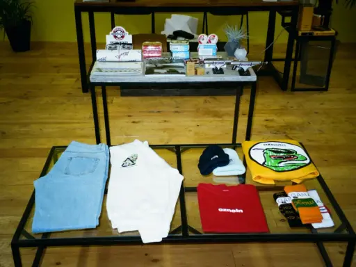 Ubrania i akcesoria, jak dżinsy, koszulki, czapki i skarpetki, to przykład tego, co to jest merchandising marki.
