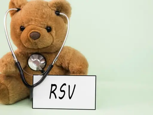 Miś z stetoskopem i tabliczką "RSV". Choć kojarzy się z dziećmi, objawy RSV u dorosłych mogą być groźne.