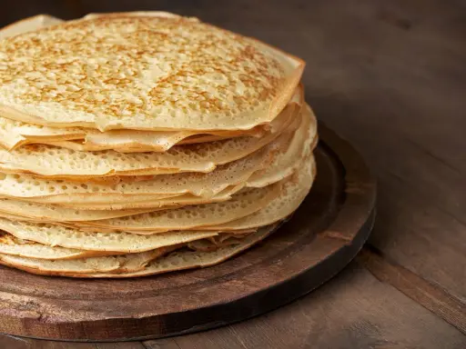 En hög med gyllene pannkakor, redo att serveras. Perfekt för ett enkelt pannkakor recept.