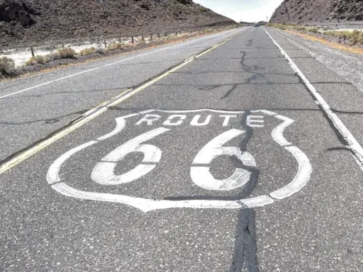 La Route 66, symbole de liberté et d'aventure, s'étend sur l'asphalte craquelé. Sa signification est immense pour les voyageurs.