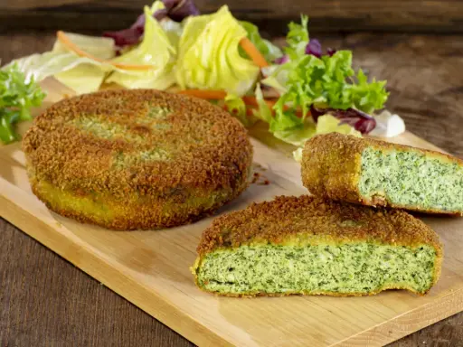 Deliziose spinacine fatte in casa, dorate e croccanti, servite con un'insalata fresca su un tagliere di legno.