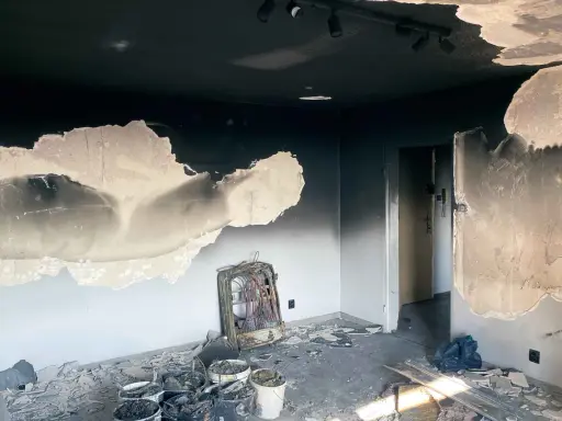 Spalone wnętrze, okopcone ściany i sufit. Na podłodze gruz, wiadra z odpadami i zniszczony grzejnik. Zastanawiasz się, czym zmyć okopcone ściany po pożarze?