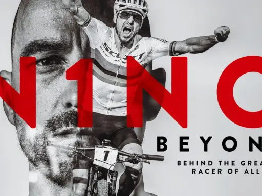 Nino Schurter, der legendäre Mountainbiker, feiert einen Sieg. Großbuchstaben "N1NO" überlagern sein Gesicht und seine Rennszene.
