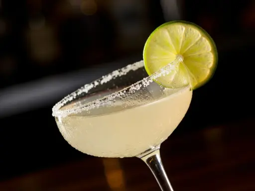 En svalkande margarita med saltkantad glaskant och en limeklyfta, redo att avnjutas mellan lakanen.