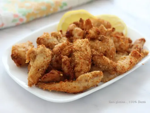 Straccetti di pollo in friggitrice ad aria, croccanti e dorati, serviti con spicchi di limone. Perfetti per un pasto leggero e gustoso.