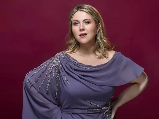 En svensk operasångerska i en elegant lila klänning med gnistrande detaljer.