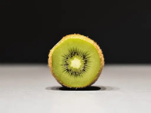 Połówka kiwi, idealna na keto, z widocznymi czarnymi pestkami i zielonym miąższem.