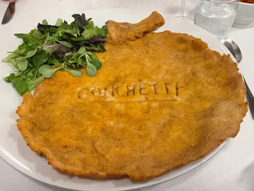 Cosa mangiare a Milano? Una cotoletta gigante con insalata fresca, un classico da provare assolutamente!