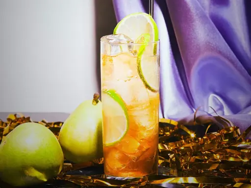 En uppfriskande drink med päron och lime, perfekt för svenska drinkar. Guldfärgad konfetti och lila tyg skapar festlig stämning.