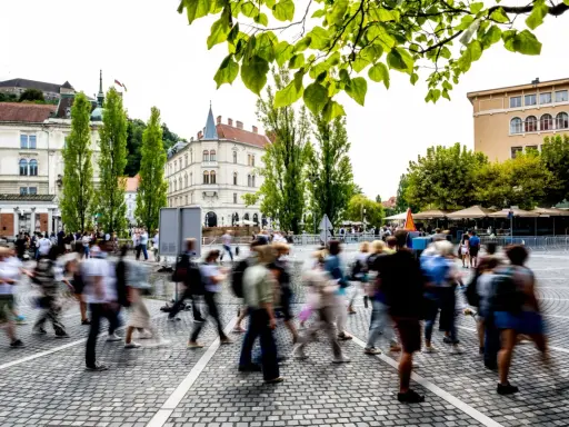 Menschen beleben den Platz, ein Beispiel für eine 15-Minuten-Stadt, die Bewegungsfreiheit und Gemeinschaft fördert.
