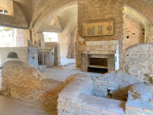 Antike Küche in Ostia Antica mit Backofen, Kamin und Wandmalerei.