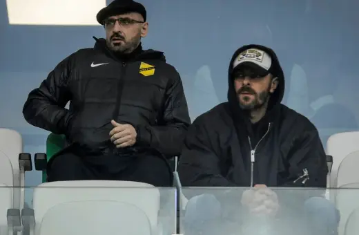 Właściciel wieczystej kraków, w czapce i okularach, siedzi obok mężczyzny w bluzie z kapturem.