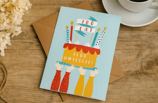 Kartka z tortem i świeczkami, z napisem "100 LAT ALBO DWIEŚCIE!". Wesołe, pozytywne życzenia urodzinowe.