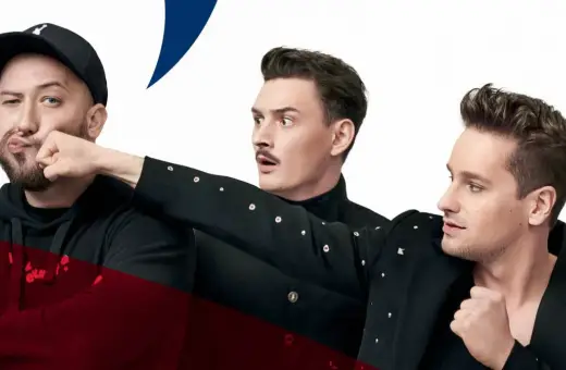 Trzech mężczyzn w czarnych strojach, jeden w czapce z daszkiem, przygotowuje się do męskiego grania. Orkiestra czeka na początek.