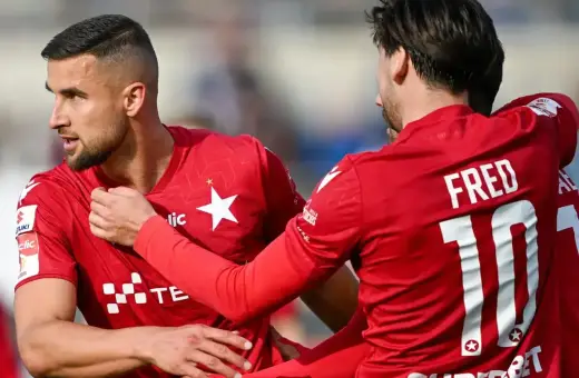Piłkarze w czerwonych strojach świętują bramkę. Jeden z nich, z numerem 10 i nazwiskiem FRED, cieszy się z awansu do Ekstraklasy.