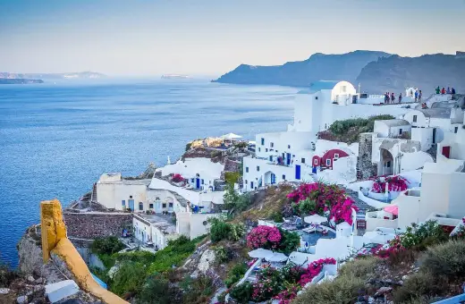 Malownicze białe domy na Santorini, kwitnące bugenwille i błękitne morze. Czy do Grecji potrzebny jest paszport? Tak, jeśli nie jesteś obywatelem UE.