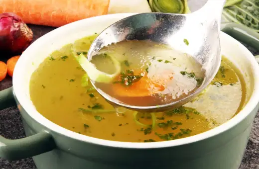 Łyżka nabiera aromatyczny rosół z warzywami. Idealny przepis na to, jak ugotować rosół, który rozgrzeje serce.
