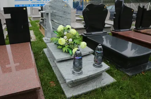 Kwiaty i znicze jako dekoracja grobu. Wokół pomnika można położyć takie ozdoby.