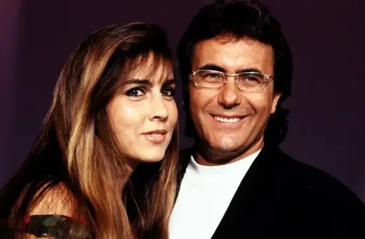 Al Bano i Romina Power, uśmiechnięci, pozują do zdjęcia. Ona ma długie, brązowe włosy, on okulary.