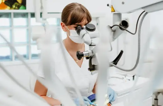 Dentystka pod mikroskopem. Zastanawiasz się, ile kosztuje wypełnienie zęba? Precyzyjna praca stomatologa.