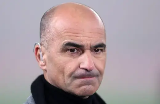 Martinez, trener z charakterystycznym aparatem słuchowym, patrzy wprost.