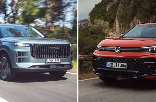 Dwa SUV-y na drodze: szary z pionową atrapą i czerwony Volkswagen SUV z charakterystycznym logo.
