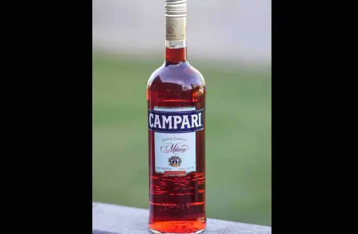 Butelka czerwonego likieru Campari z etykietą "Davide Campari Milano".