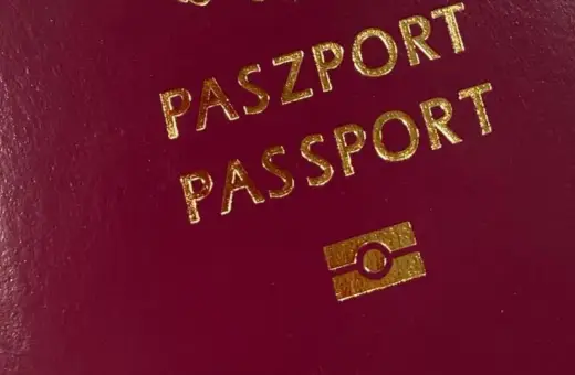 Ciemnoczerwony paszport z napisem "PASZPORT" i symbolem. Numer paszportu jest ukryty.