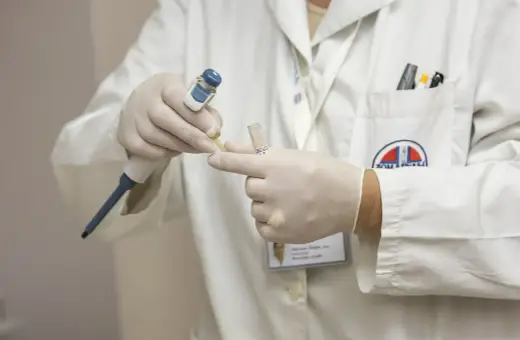 Ręce w rękawiczkach pobierają próbkę do analizy. To część procesu, który może pomóc odpowiedzieć na pytanie: obdukcja co to.