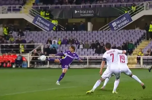 Piłkarz Fiorentiny w akcji podczas meczu z Interem Mediolan. Piłka leci w powietrzu, a zawodnik próbuje ją kopnąć.