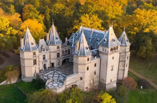 Piękny zamek w otoczeniu jesiennych drzew. Wspaniały przykład zamków w Polsce, zachwyca architekturą i kolorami.
