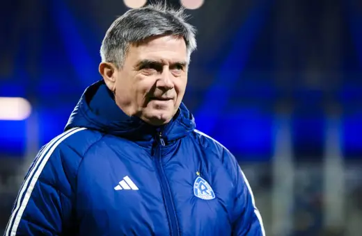 Doświadczony trener Ruchu Chorzów w niebieskiej kurtce z herbem klubu.