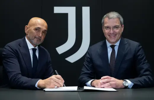 Dwóch mężczyzn w garniturach siedzi przy stole. Jeden z nich, łysy, podpisuje dokument. Za nimi logo Juventusu.