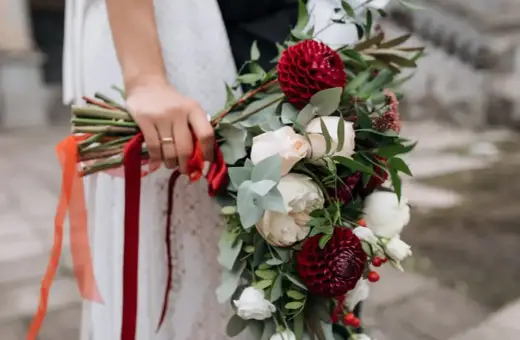 Wrześniowy bukiet ślubny z bordowymi daliami, kremowymi różami i zielenią. Idealne kwiaty we wrześniu na ślub.