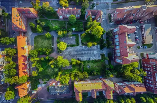 Widok z lotu ptaka na zabudowania i zieleń w Świnoujściu. Spacer po promenadzie i odkrywanie jej atrakcji z tej perspektywy to niezapomniane wrażenia.