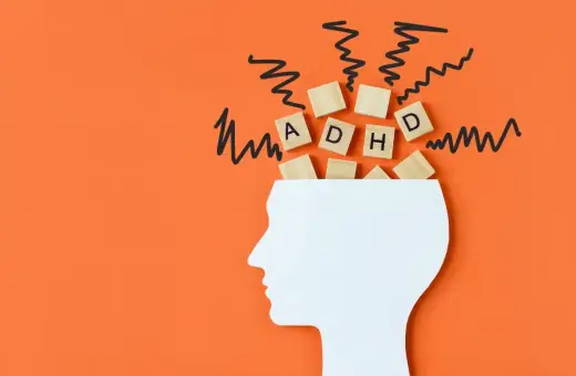 Drewniane klocki z literami "ADHD" wypadają z głowy, symbolizując chaos myśli. To wizualizacja problemów z koncentracją, które mogą pojawić się w wyniku **autyzmu nabytego**.