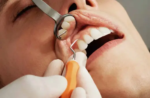 Dentysta bada zęby pacjenta. Zastanawiasz się, ile trwa wyrywanie zęba 6?