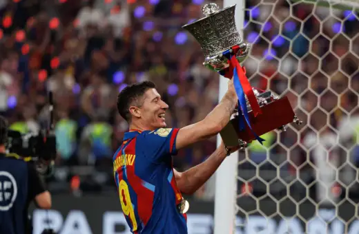 Robert Lewandowski z pucharem, symbol jego bogatej kariery. Krótka biografia tego piłkarza to historia sukcesów.