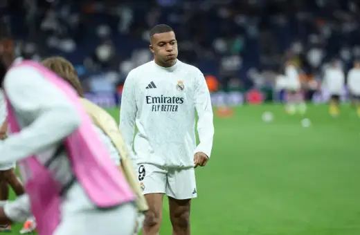 Mbappé, młody piłkarz Realu Madryt, w białej koszulce treningowej z logo Emirates.