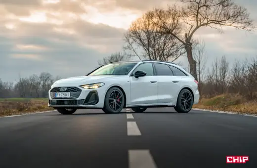 Białe Audi A5 Avant 2025 na drodze, z drzewami w tle.