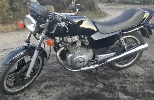 Czarny motocykl Honda CB250T z lat 80. stoi na ziemi.