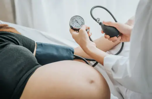 Kobieta w ciąży ma mierzone ciśnienie. Monitorowanie ciśnienia jest kluczowe, by uniknąć powikłań, takich jak wysokie ciśnienie w ciąży.
