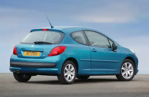 Niebieski Peugeot 207 1.6 HDI z 2007 roku, widok z tyłu, na tle błękitnego nieba.